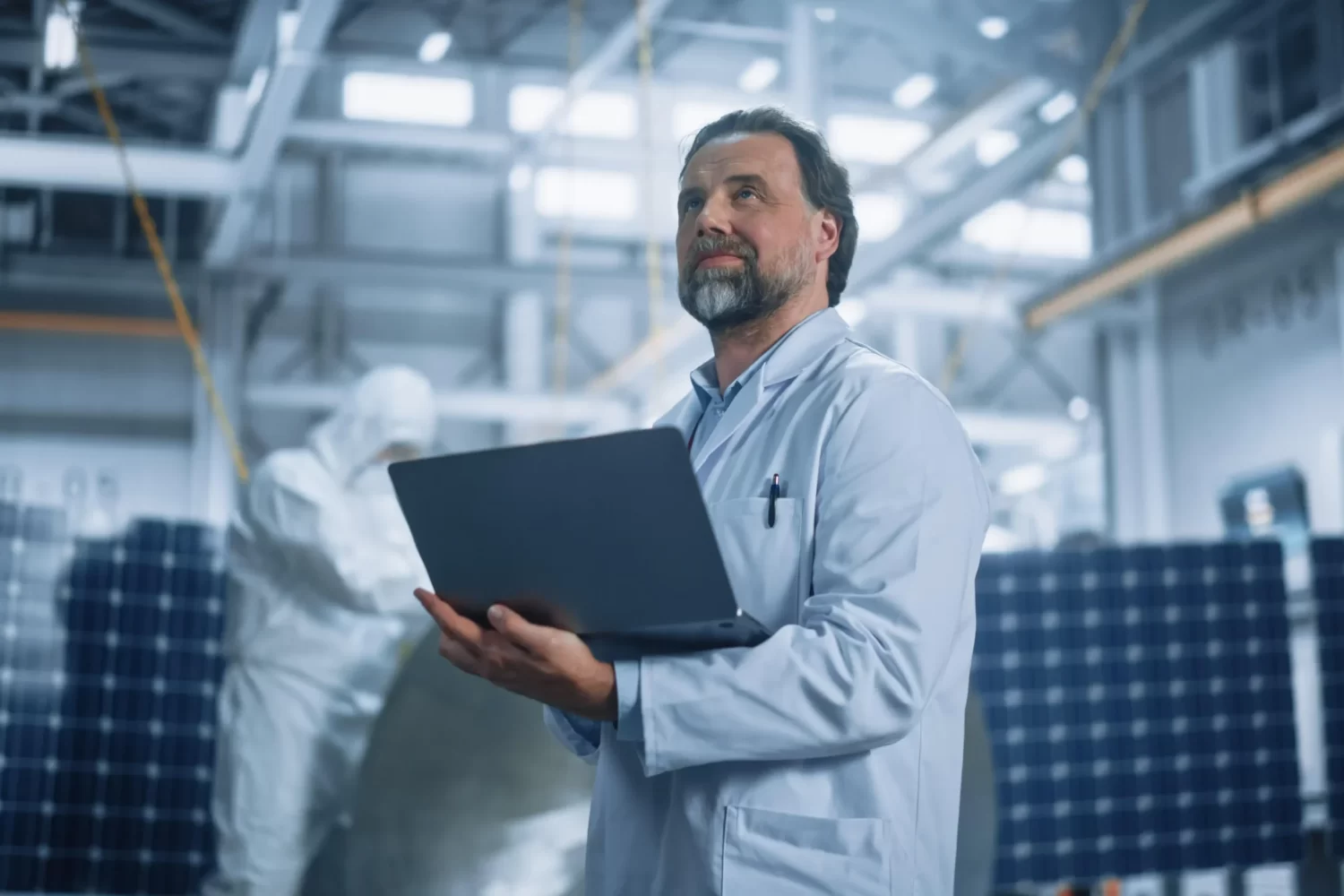 man-lab-coat-stands-front-solar-panel